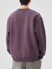 Plus-size long-sleeve sweatshirt in purple with crewneck and ribbed cuffs and hem.