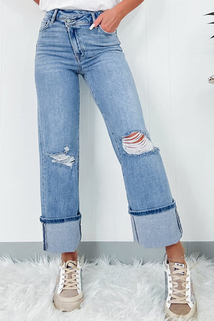 Medium wash denim wide-leg jeans with distressed knees and cuffed hems.