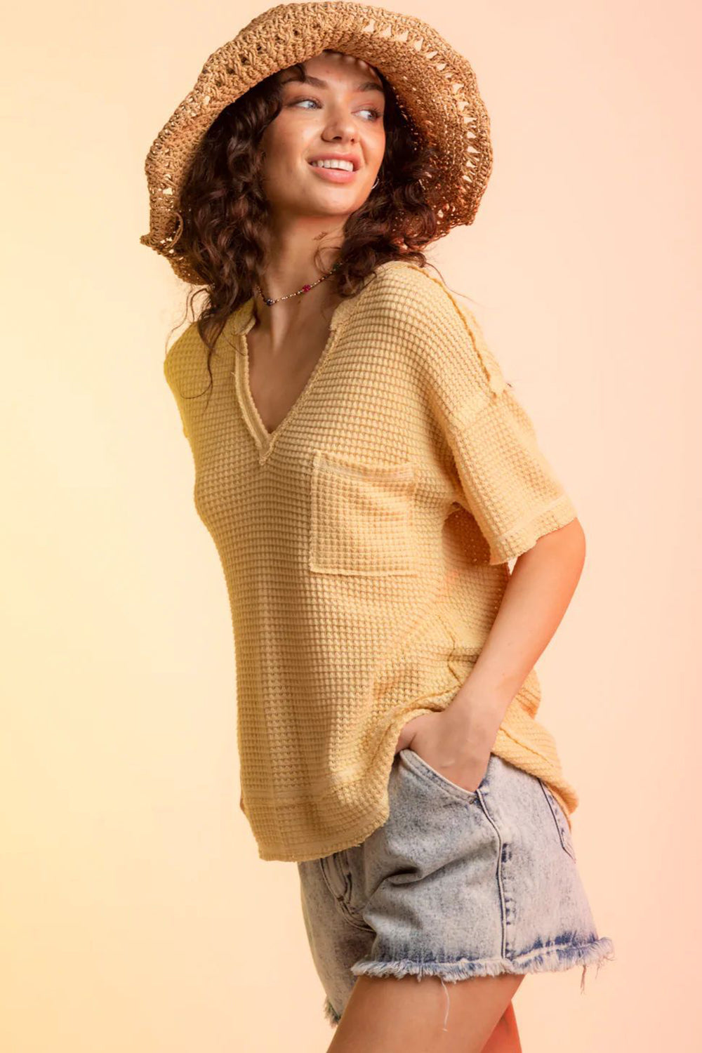 Yellow waffle knit v-neck top with short sleeves and a chest pocket.