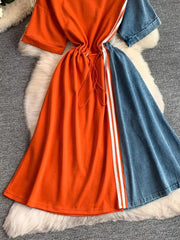 Color block casual dress with drawstring waist, orange and denim panels, and white stripe detail.