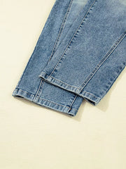 Light wash denim maternity jeans with cuffed hems and visible seams.