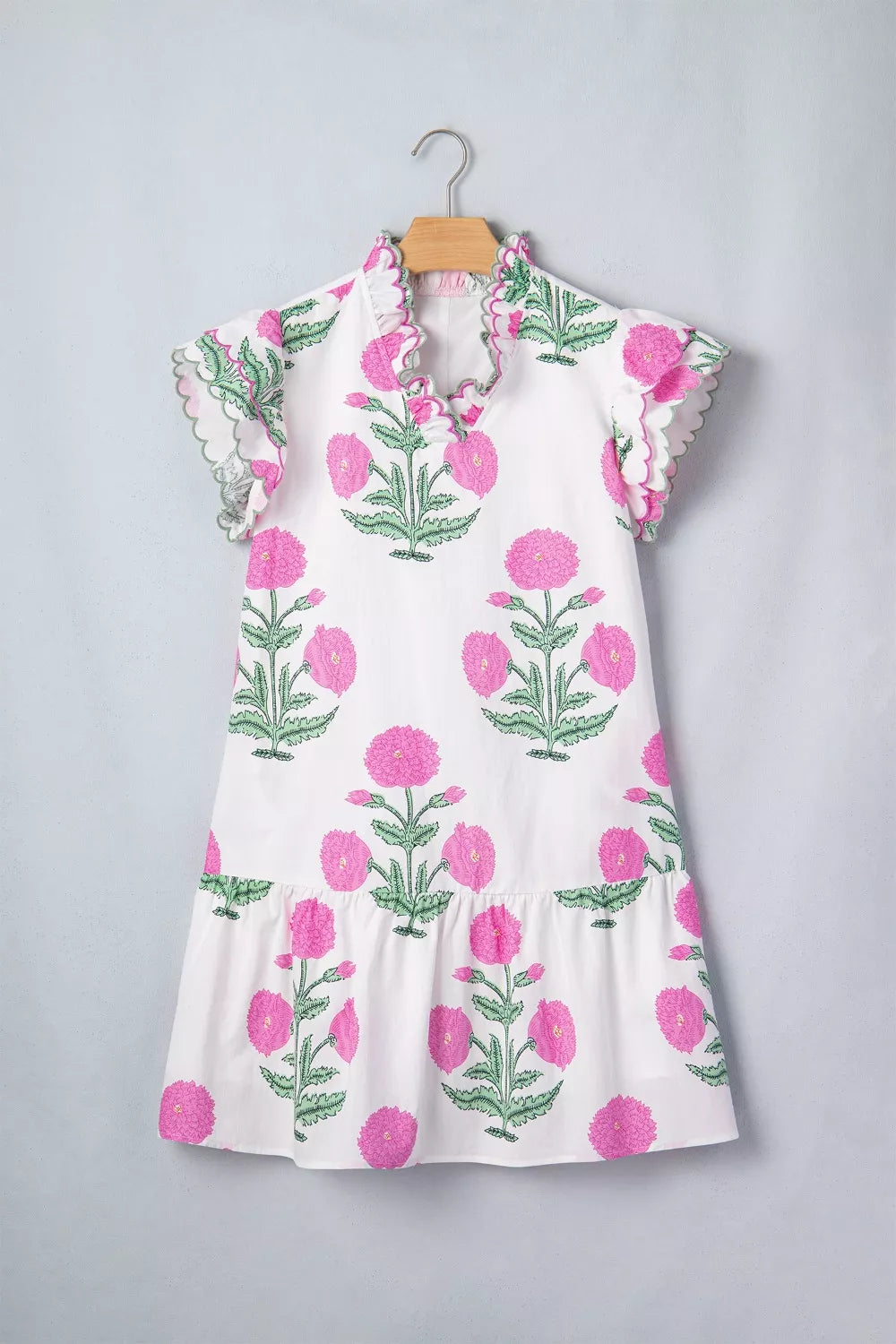 White mini dress with vibrant pink floral print, ruffled neckline and sleeves.