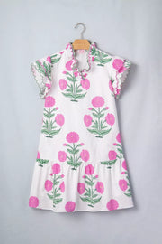 White mini dress with vibrant pink floral print, ruffled neckline and sleeves.