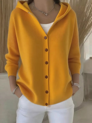 Yellow hooded knit cardigan with button front and wooden buttons, worn over a white tank top.