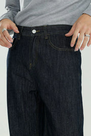 Dark wash wide-leg denim jeans with relaxed fit and yellow stitching.