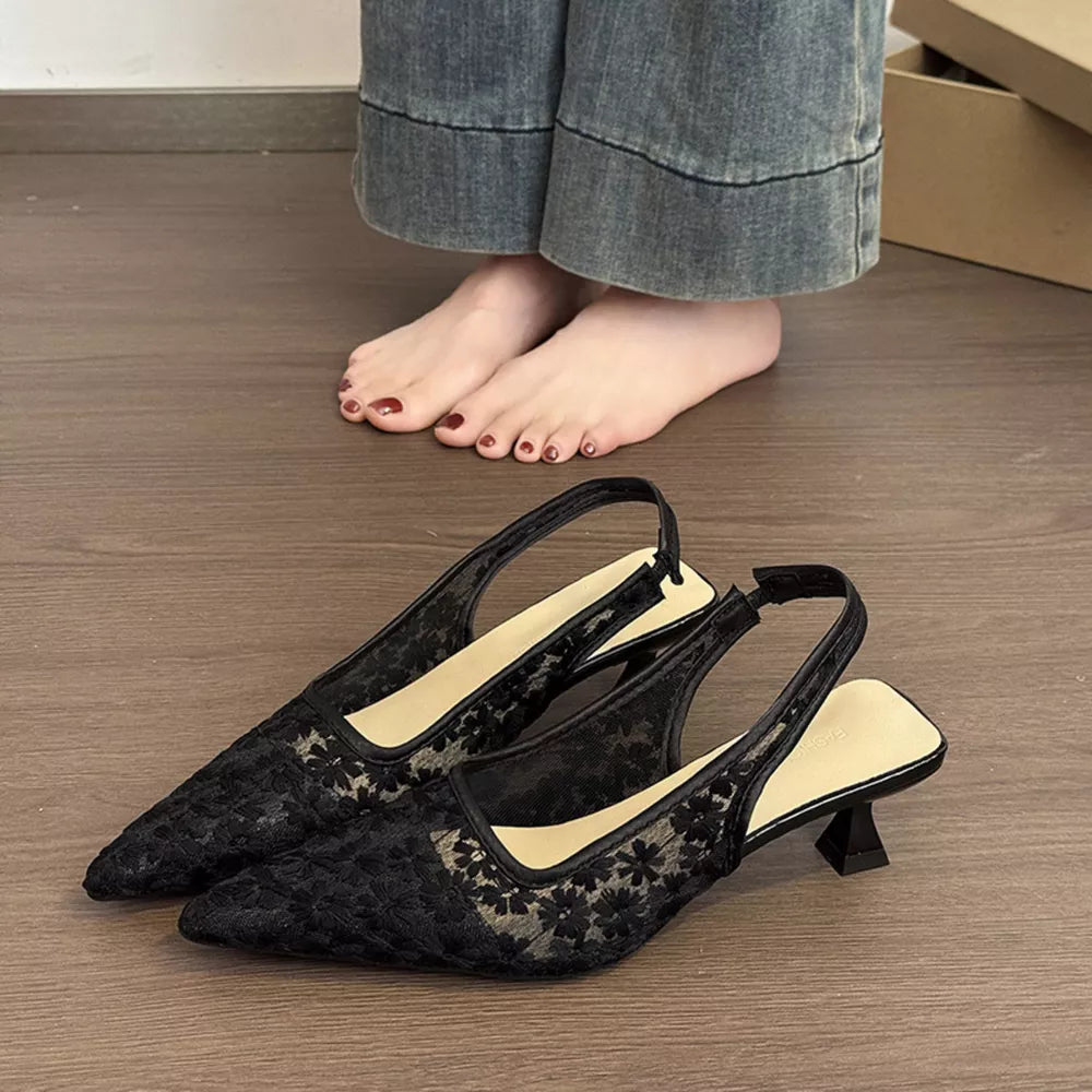 Black lace slingback kitten heels with floral pattern and pointed toe.