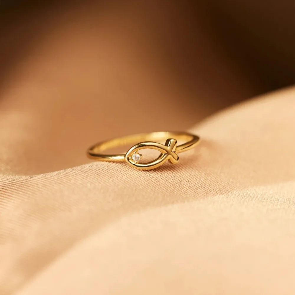 Gold ring with delicate fish motif and small zircon accent