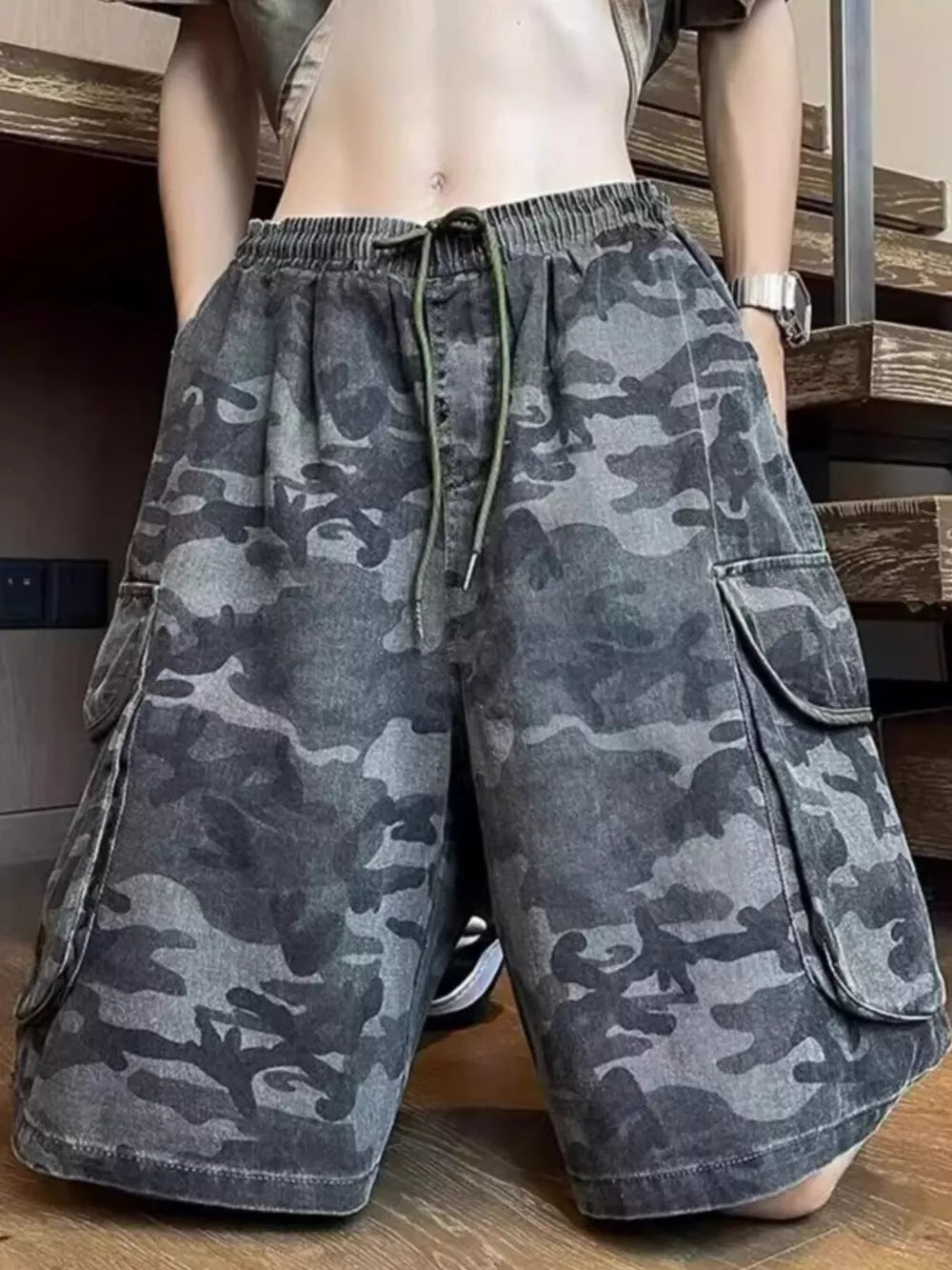 Relaxed fit black camo cargo shorts with drawstring waist and multiple pockets.