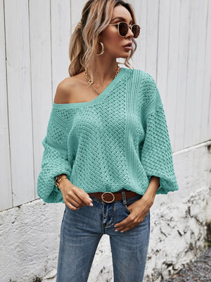Teal open-knit sweater with balloon sleeves and a v-neck, styled with jeans.