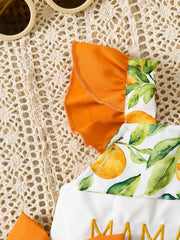 Baby one-piece with orange and leaf print, orange ruffles, and embroidered text.