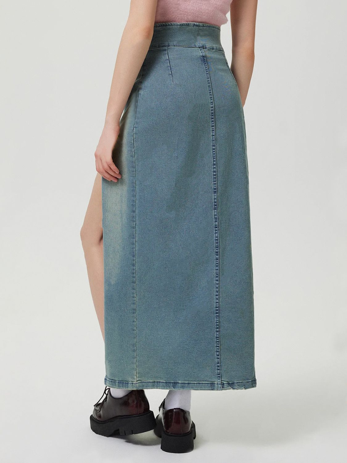 Denim maxi skirt in medium wash with a high slit front and button closure.