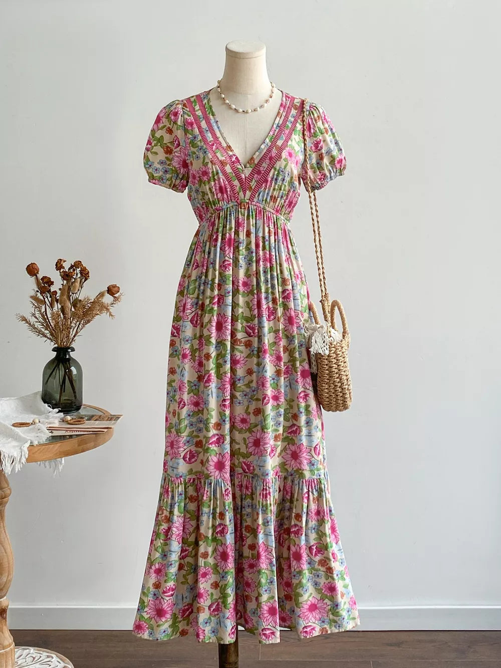 Maxi dress with floral print, V-neck, puff sleeves, and decorative trim.