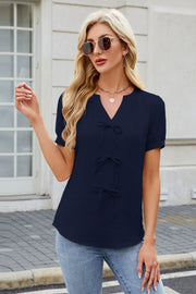 Dark Navy textured V-neck blouse with three bow details and short sleeves.