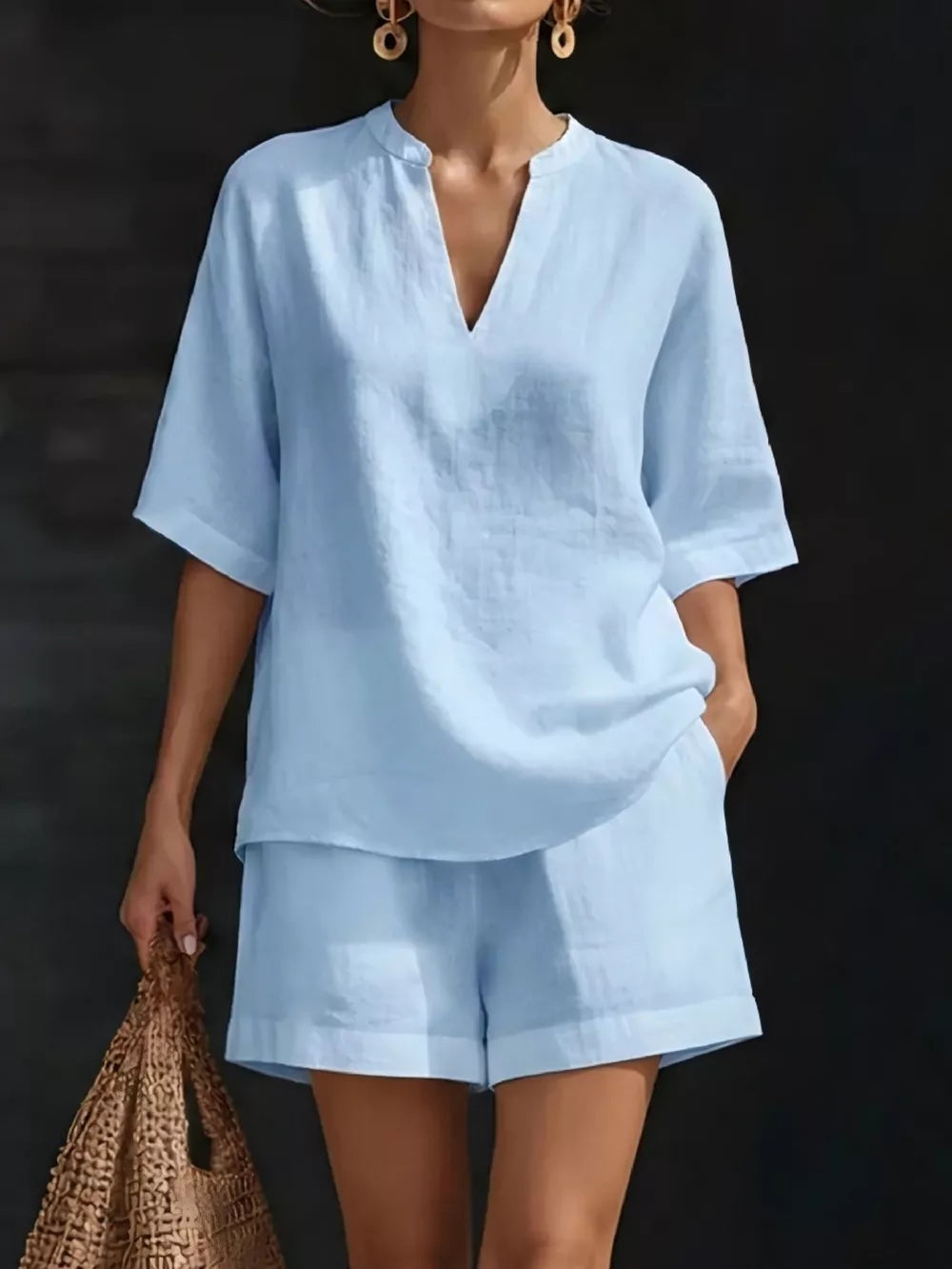 Light blue notched V-neck two-piece set with pockets and cuffed shorts.