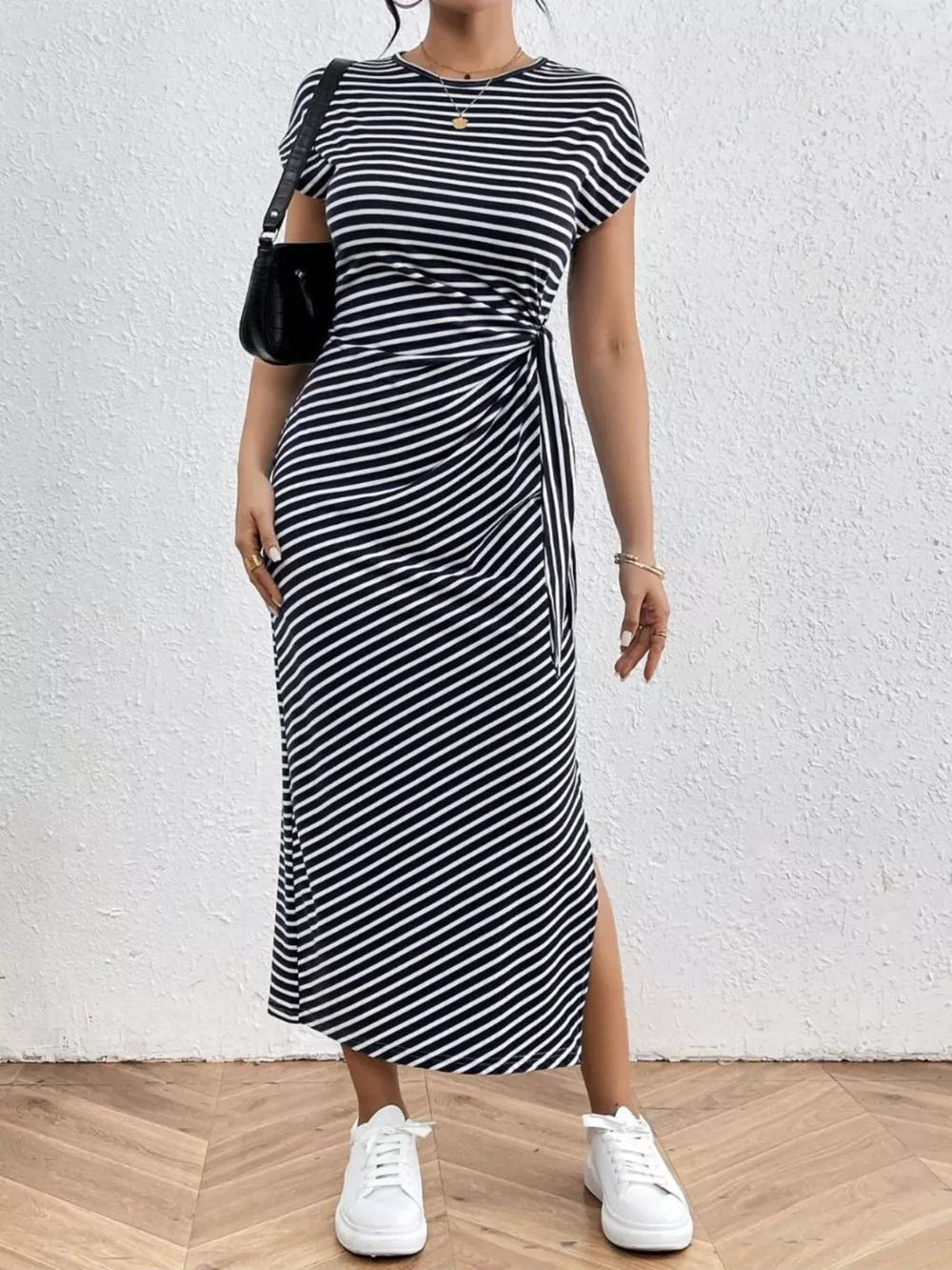 Black and white striped midi dress with tie-side detail and leg slit.