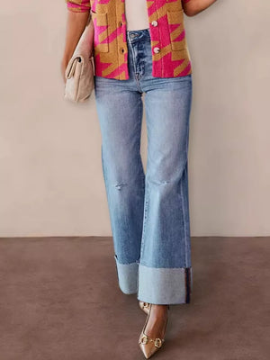 Distressed high-waisted flare maternity jeans with raw hem and cuffed ankles.