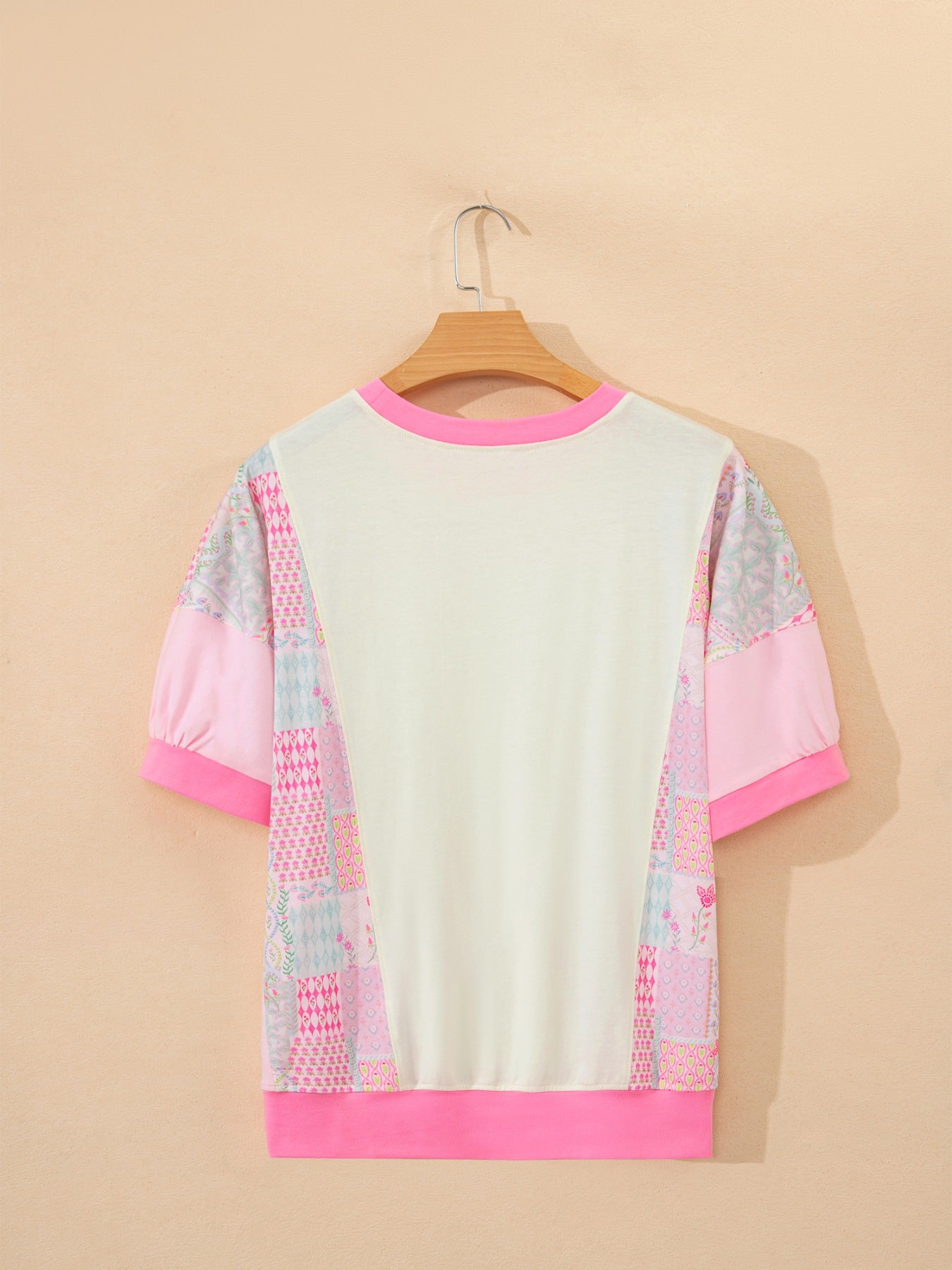 Maternity t-shirt with patchwork floral print sleeves, crew neck, and pink trim.