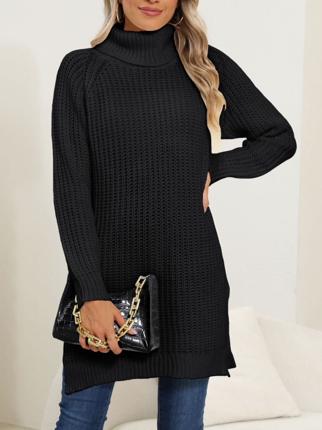 Black knit turtleneck sweater with asymmetric hemline and long sleeves.