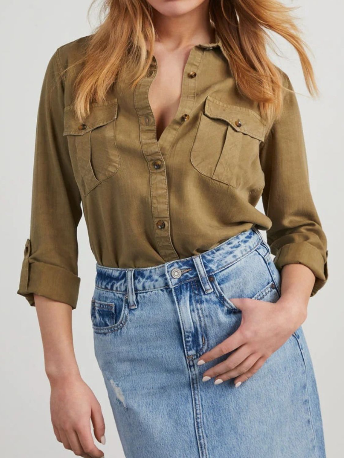 Olive brown washed denim utility shirt with buttoned chest pockets and rolled sleeves.