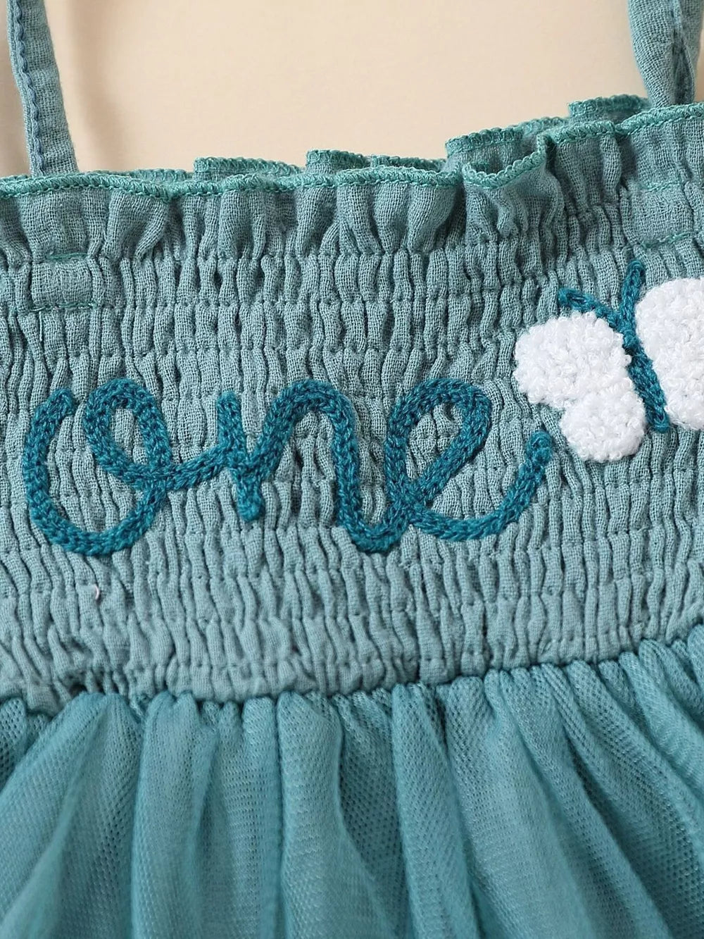 Sea blue smocked baby bodysuit with embroidered "one" and butterfly detail