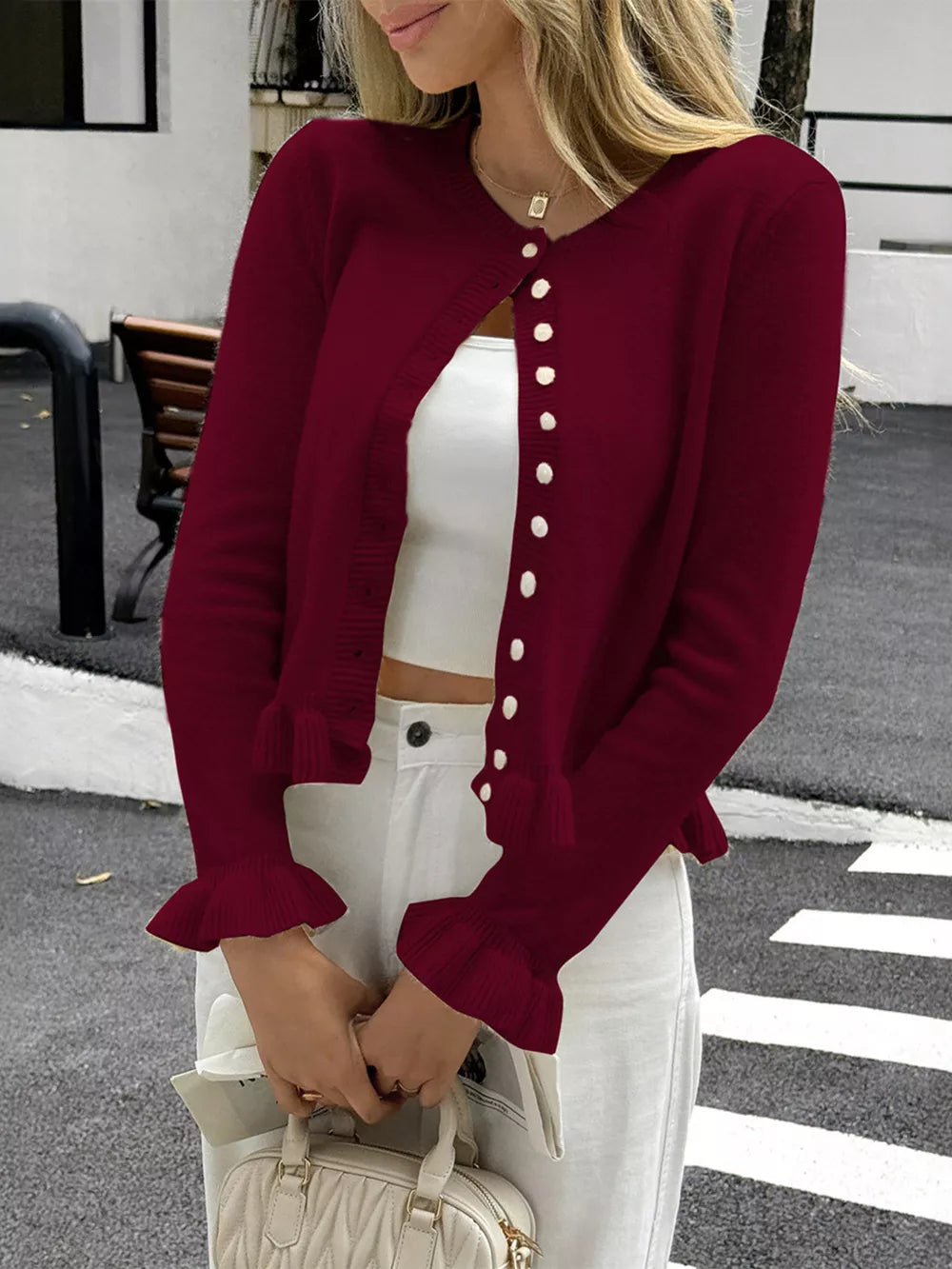 Burgundy knit cardigan with ruffled cuffs and button front.