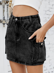 Black denim cargo mini skirt with button closure and utility pockets.