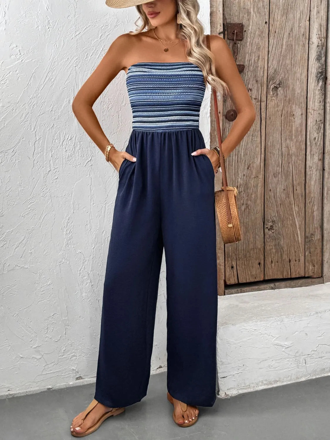 Dark blue bandeau palazzo jumpsuit with striped smocked bodice and wide legs.