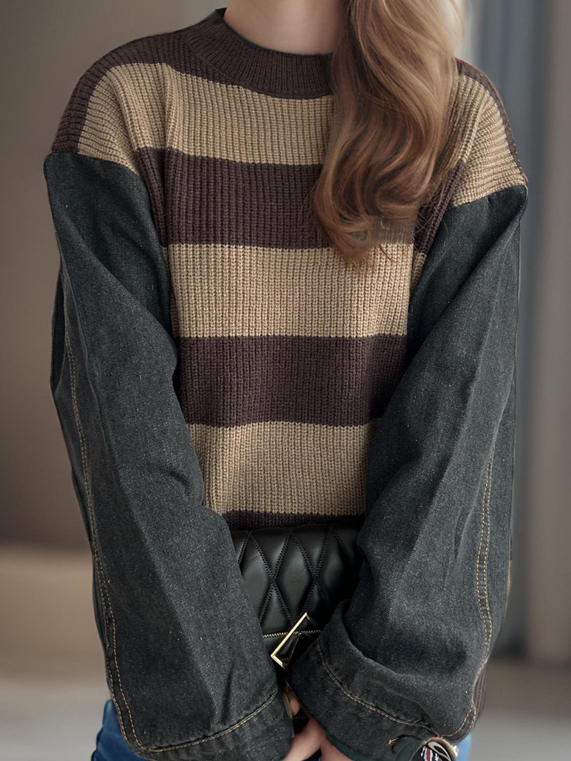 Brown and tan striped knit sweater with dark denim sleeves.