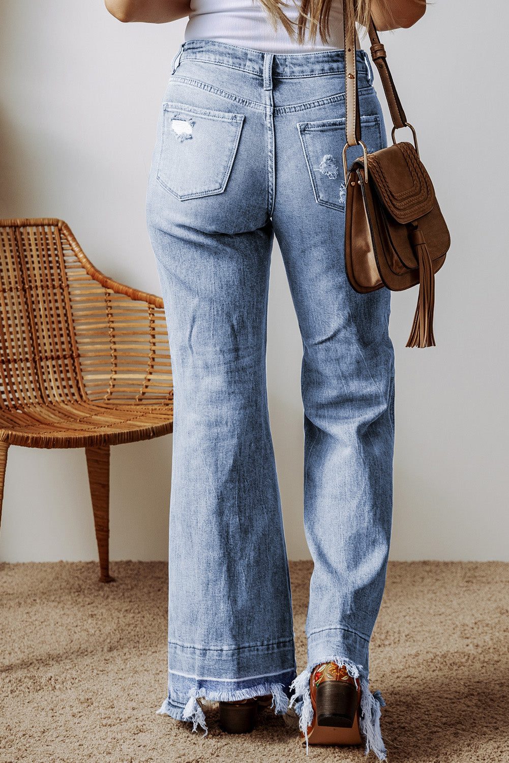 Medium wash flare jeans with raw hem and distressed details.