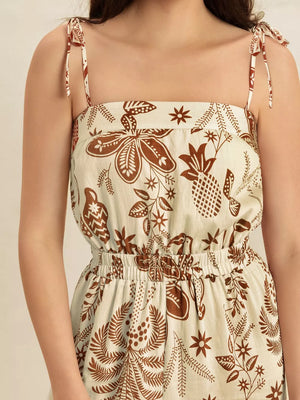 Tropical tie strap romper with square neckline and elastic waist in a brown floral print.