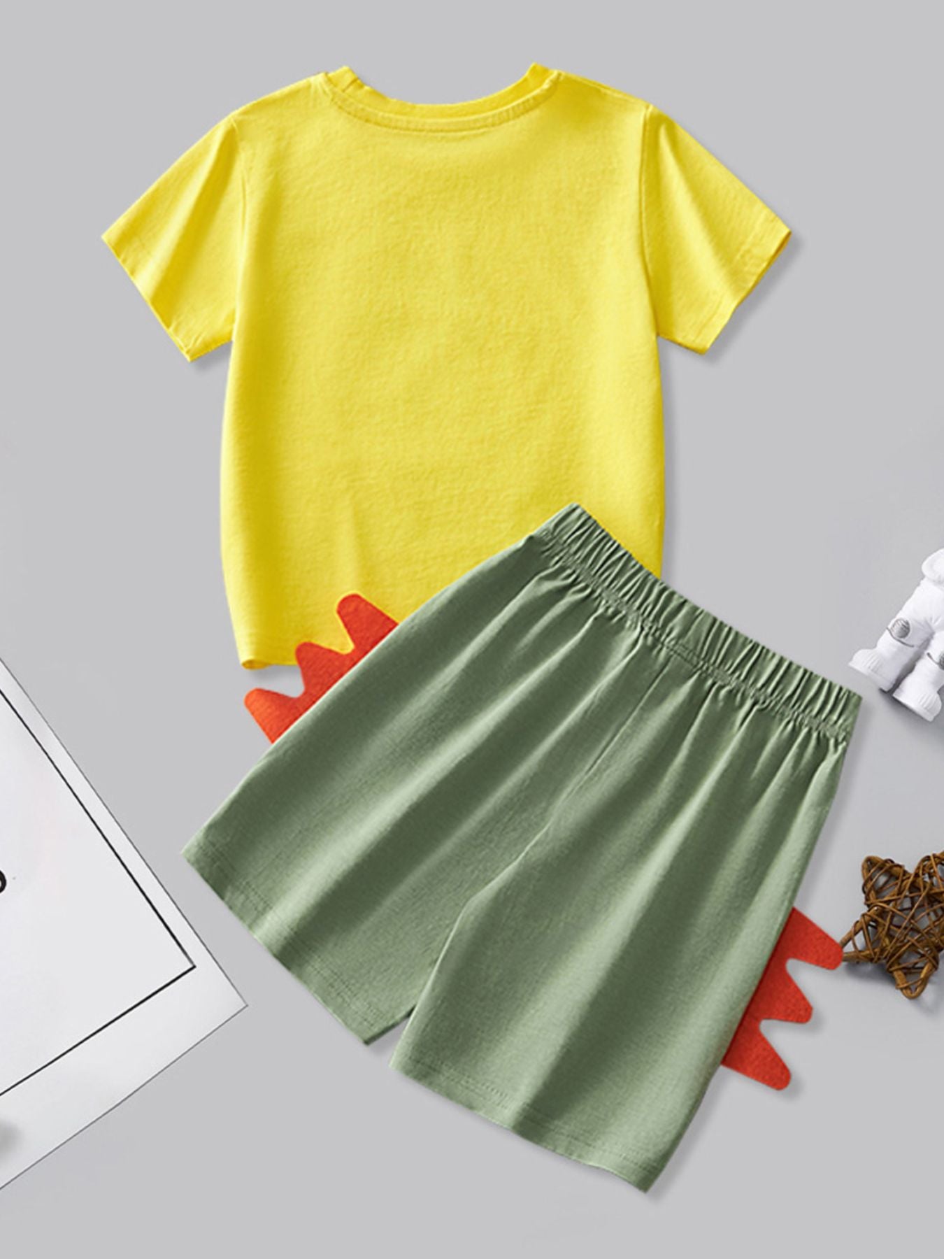 Toddler dinosaur tail shorts set with yellow t-shirt and green shorts.