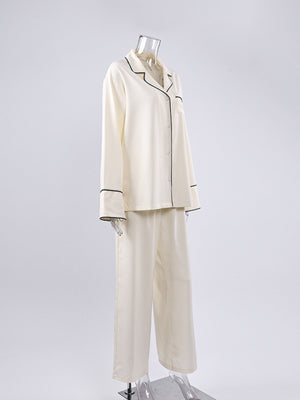 Cream button-up pajama set with black piping details and long sleeves.