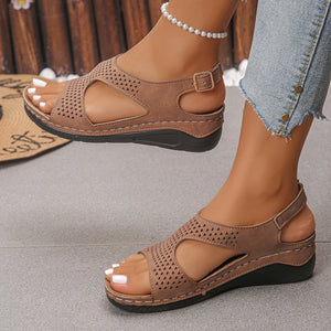 Brown cutout wedge sandals with ankle strap and adjustable buckle detail.