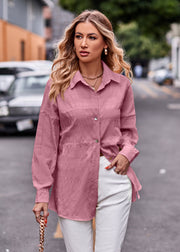 Dusty pink textured overshirt with relaxed fit and buttoned front, styled with white pants.