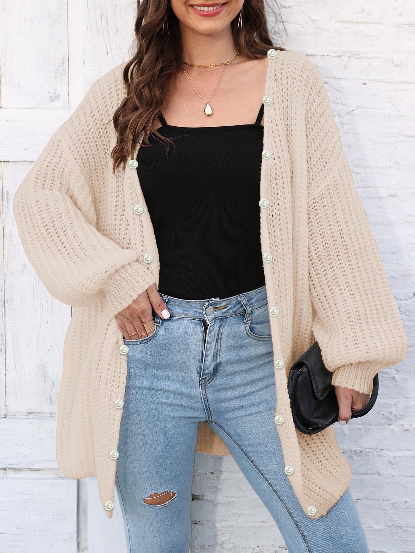 Tan balloon sleeve cardigan with pearl buttons and open front, styled with jeans.