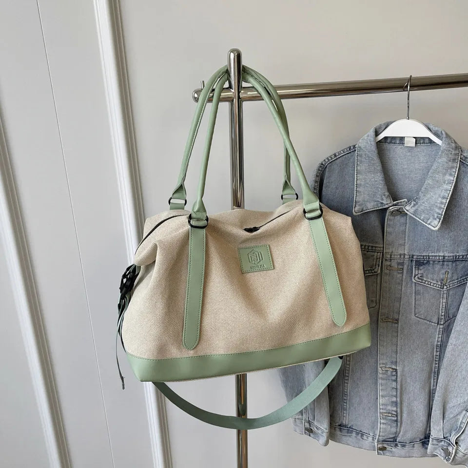 Canvas weekend holdall duffel bag in natural with mint green accents and strap.