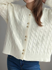 White cable knit acrylic cardigan with puff sleeves and gold buttons.