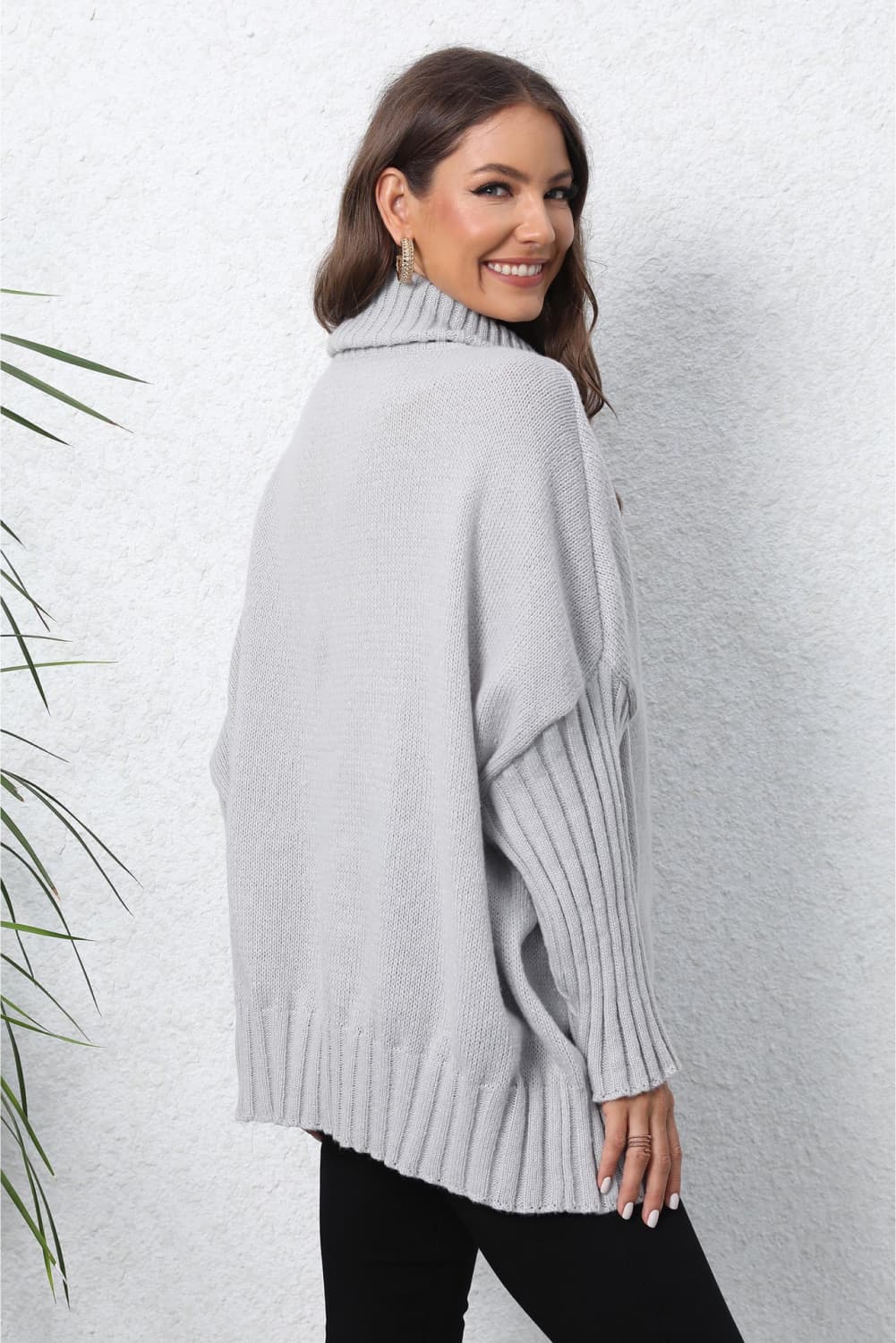 Light gray batwing knit turtleneck sweater with ribbed sleeves and hem.