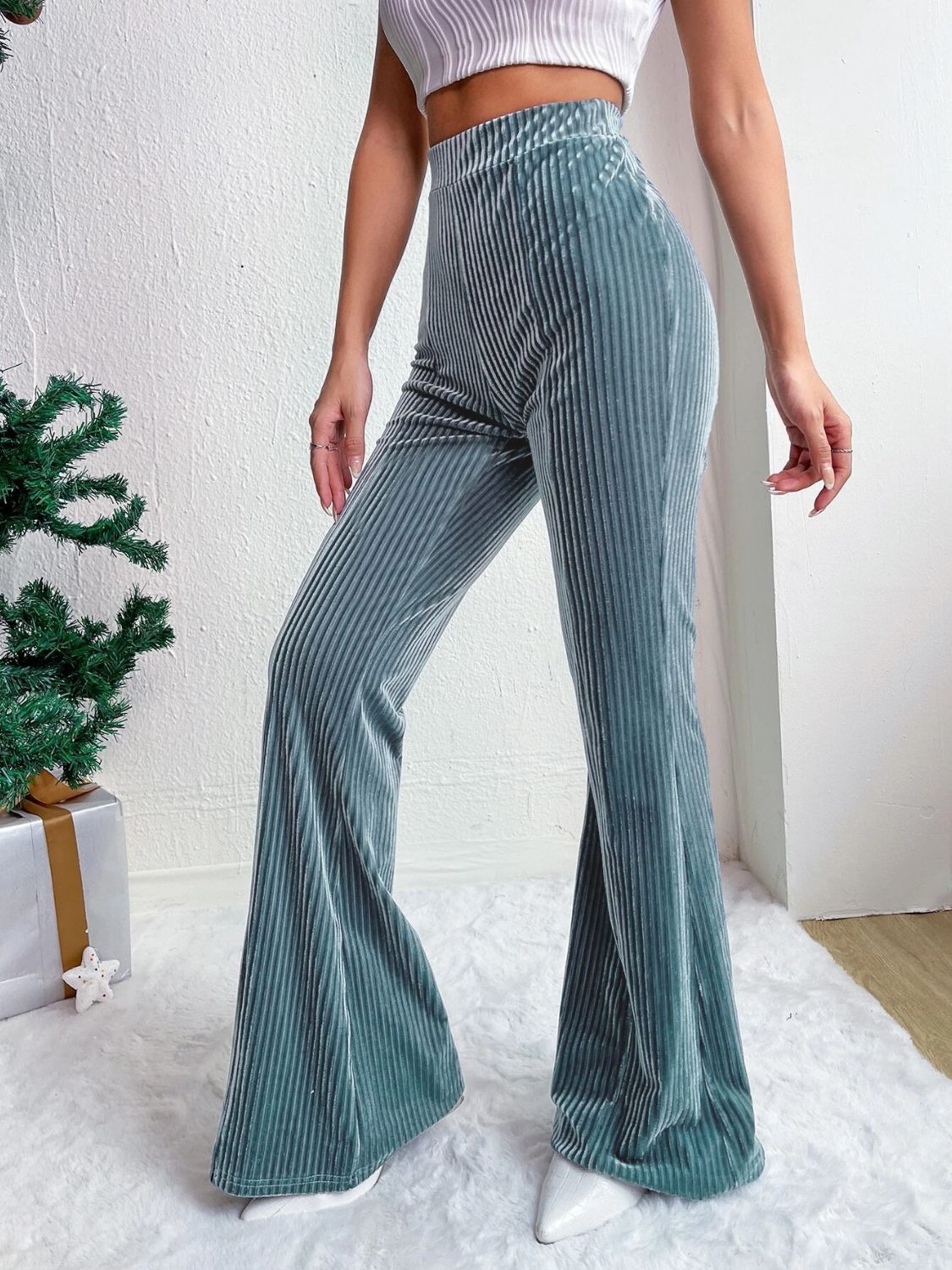 Teal corduroy bell bottom trousers with vertical ribbing.