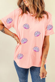 Pink tee with rolled sleeves and scattered seashell appliques.