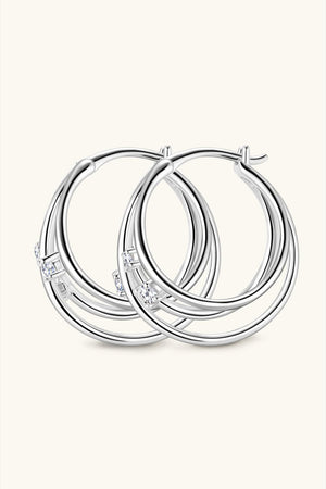 Silver hoop earrings with multiple intertwined bands and cubic zirconia accents.