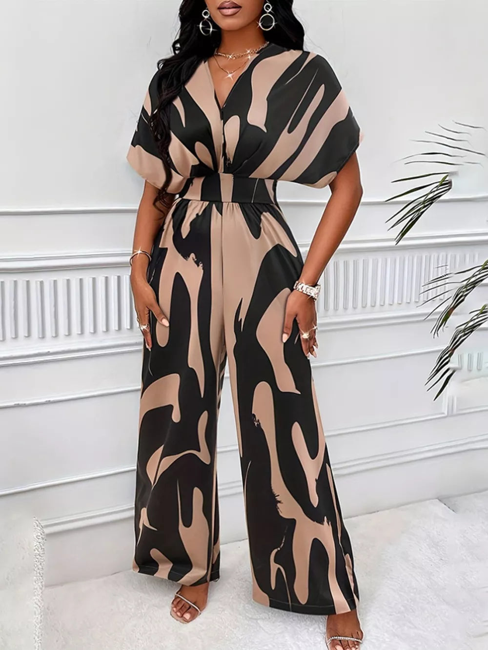 Chic abstract print wide-leg romper in black and khaki with V-neck and dolman sleeves.