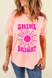 Watermelon pink t-shirt with a retro sunburst graphic and "Shine Bright" text.