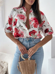Floral print blouse with mandarin collar and button front, shown in white with red flowers.