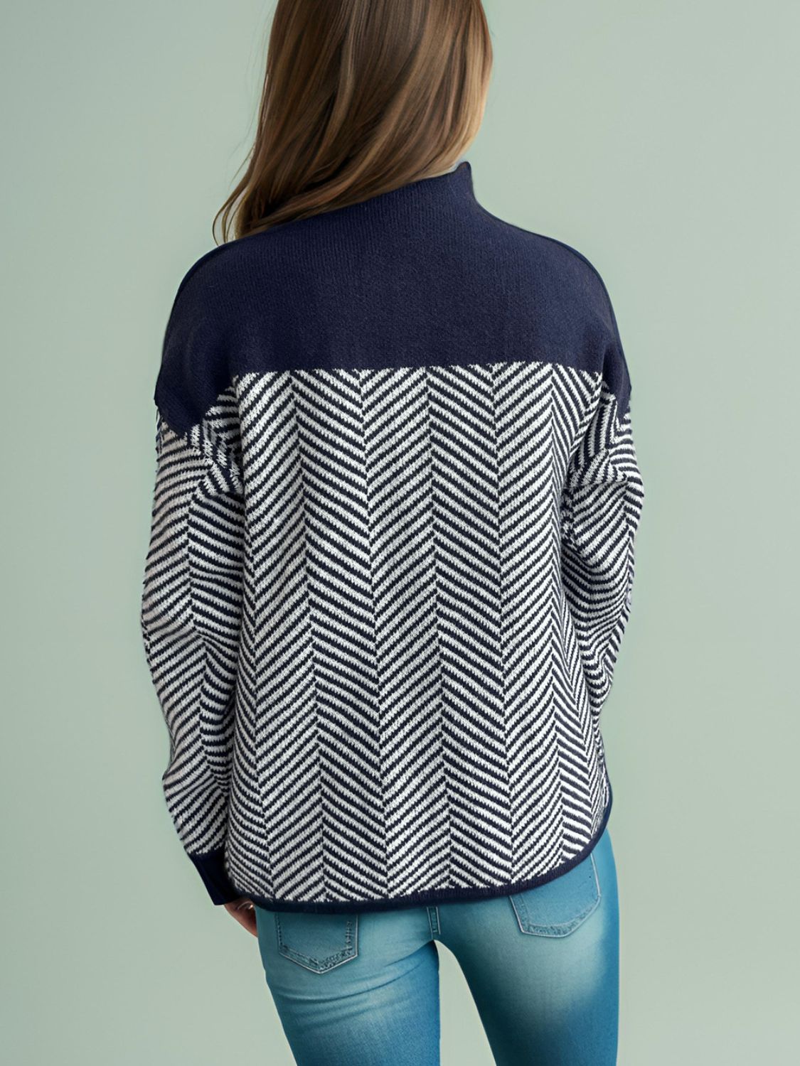 Chevron knit turtleneck sweater in dark blue and white herringbone pattern.
