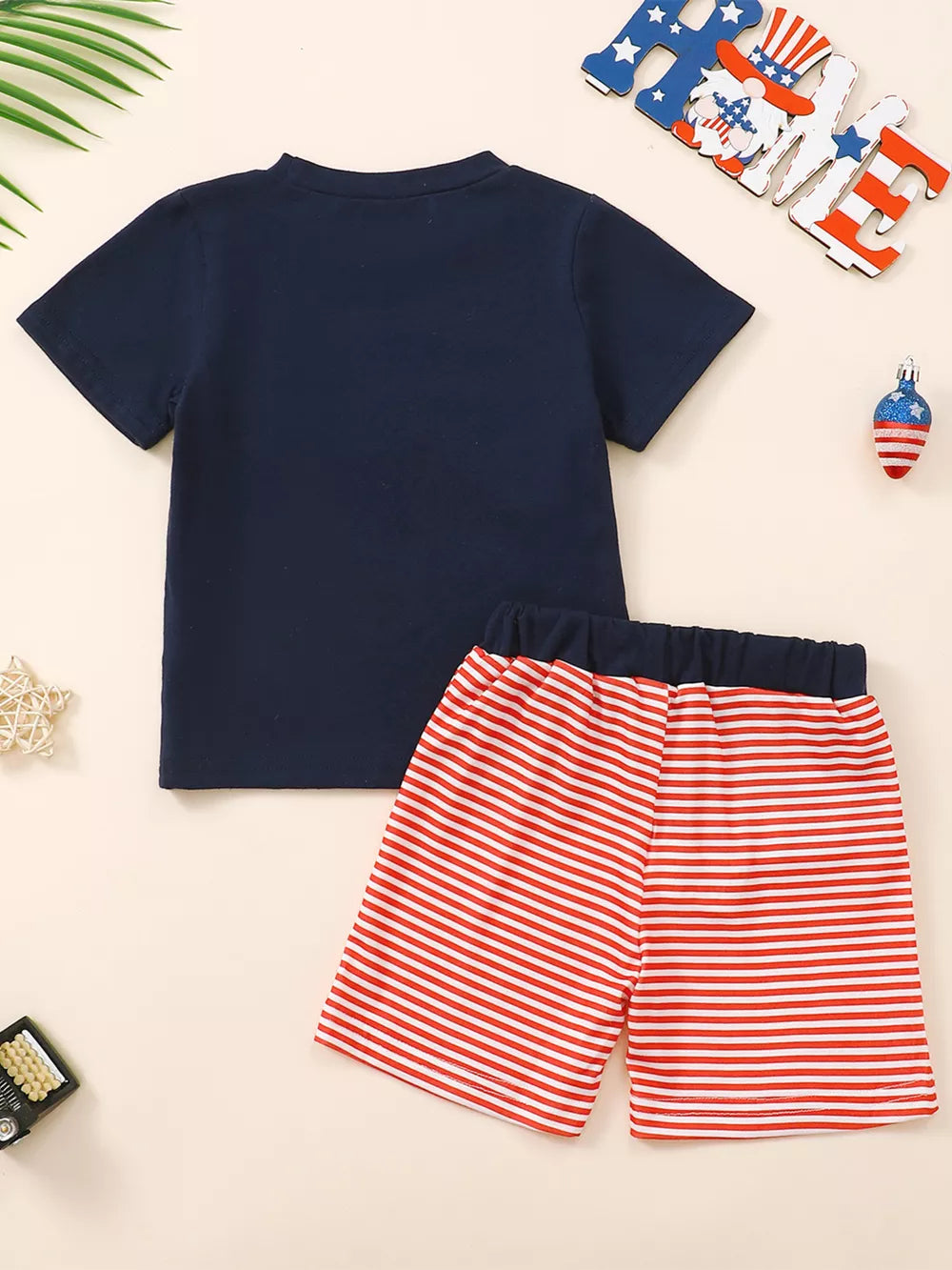 Navy baby t-shirt with red and white striped shorts.