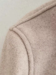 Beige trucker jacket detail showing seam and textured fabric
