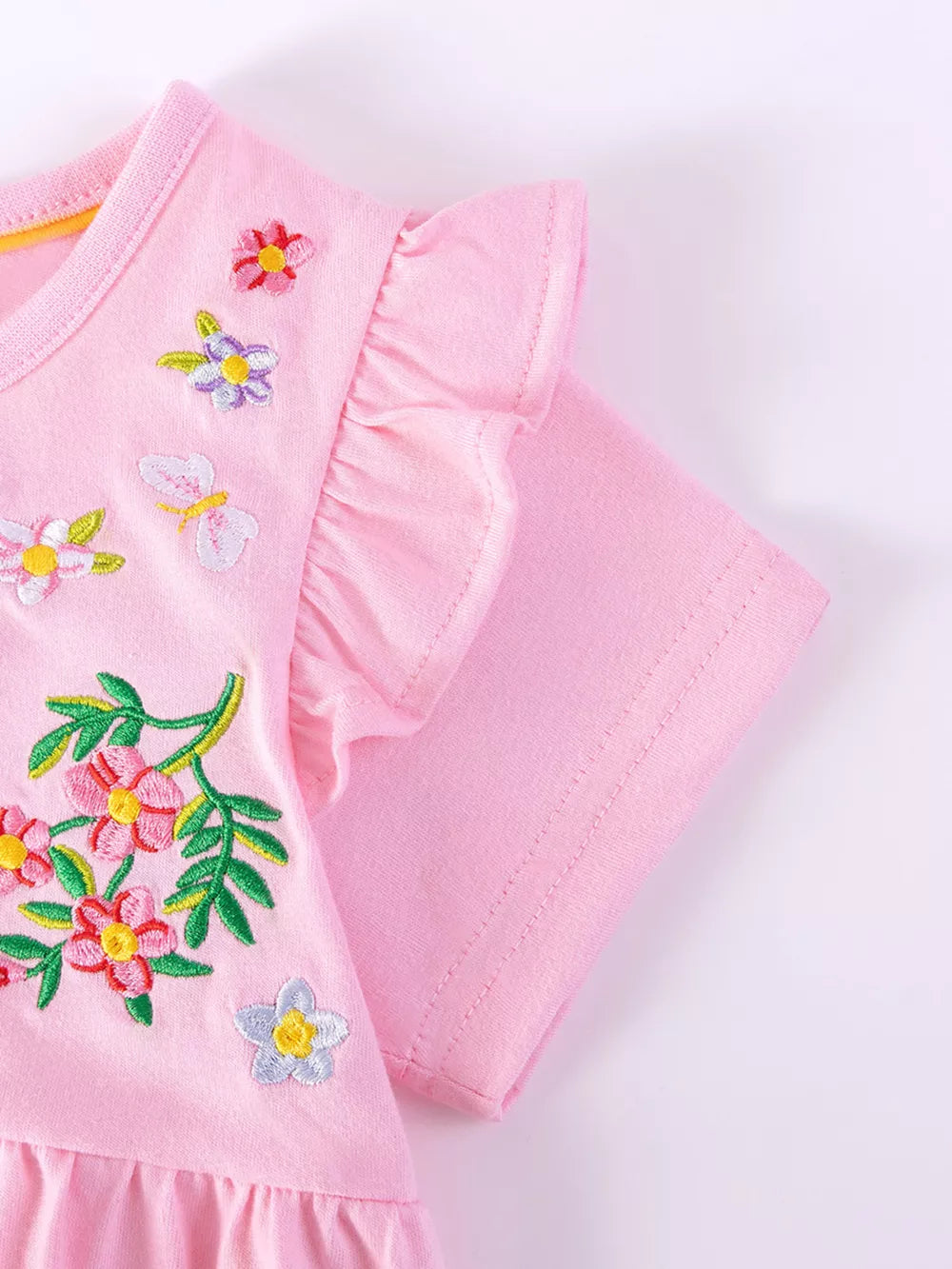 Pink cotton dress with embroidered floral and butterfly details and ruffle sleeves.