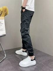 Black cotton drawstring sweatpants with cuffed ankles and side pockets.