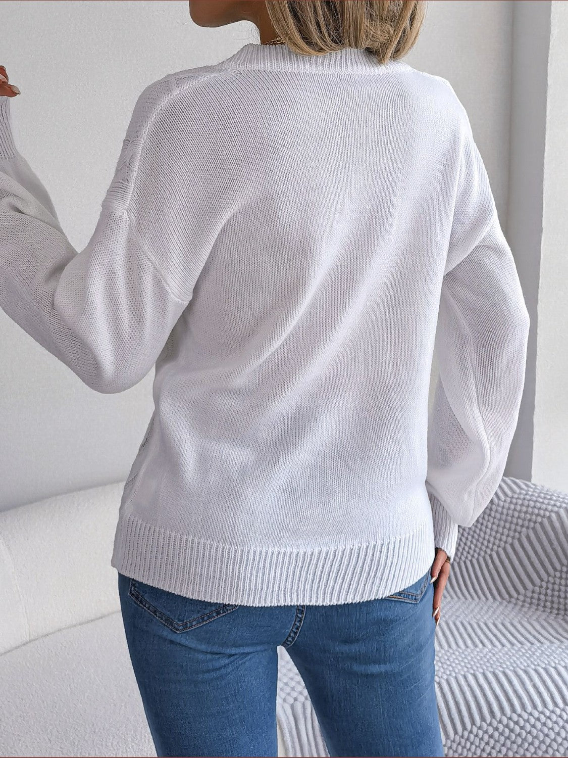 White cable knit button-front cardigan with ribbed cuffs and hem.
